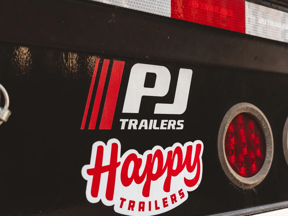 Rear detail of a PJ gooseneck trailer with reflective tape and lighting.